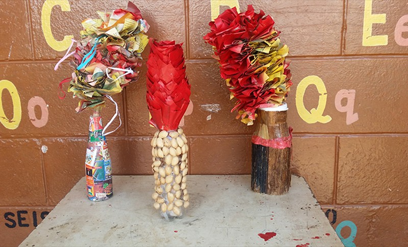 Newspaper flowers and plastic bottle and wood vase